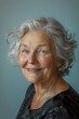 © spyrakot - Portrait of a silver-haired elderly woman smiling warmly against a pale blue background. soft lighting enhances her wisdom and kindness, making it ideal for inspirational and family-themed designs