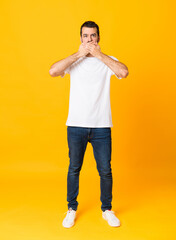 Wall Mural - Full-length shot of man with beard over isolated yellow background covering mouth with hands