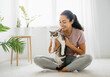 © Hanna - A young woman enjoying quality time with her cat in a bright, cozy indoor space surrounded by plants during the afternoon