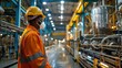 © Waraporn - Industrial factory worker wearing safety uniform and hardhat inspecting the manufacturing process and machinery in a large commercial warehouse facility