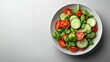 © hamzahalderad - A fresh salad with tomatoes, cucumbers and basil in a white bowl on a white background.