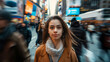 © mahamad - Young beautiful girl in a crowd of people, looking directly at the camera, with motion blur of people walking in New York City.