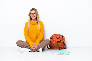 Canvas Print - Uruguayan student woman sitting one the floor isolated on white background laughing