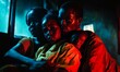 © jambulart - Three people huddle together in blue and red light.