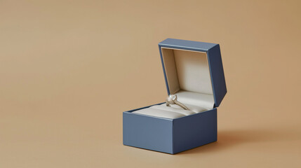 Elegant engagement ring displayed in a blue velvet box against a soft tan background