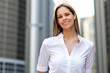 © Minerva Studio - Smiling businesswoman standing outside modern office building