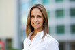 © Minerva Studio - Businesswoman smiling in front of office building