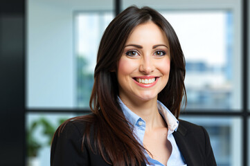 Wall Mural - Smiling businesswoman portrait in modern office setting