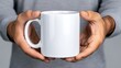 © Nataliia_Trushchenko - Man is holding a white mug in his hands. The mug is empty and has no design on it. The man's hands are positioned around the mug, and he is holding it with a sense of care and attention