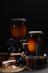 Different drums on a black background, percussion musical instruments