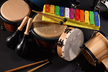 Different drums on a black background, percussion musical instruments