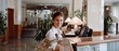 © Ai Studio - A welcoming hotel receptionist stands ready to assist at the front desk, exuding warmth and hospitality.