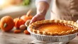 © DuangphonKPR - A person holds a delicious pumpkin pie, surrounded by fresh pumpkins and eggs, evoking a warm, festive kitchen atmosphere perfect for autumn celebrations.