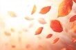 © sonderstock - Autumn leaves fall through the air with an orange blurred background.