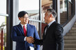© DG PhotoStock - Two Asian businesspeople having a business discussion in the office building.