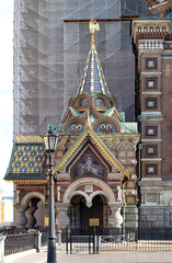 Wall Mural - tower of the Church of the Savior on Spilled Blood with mosaics and a golden eagle against the background of a camouflage net