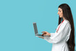 © Pixel-Shot - Beautiful young female doctor with stethoscope and laptop on blue background