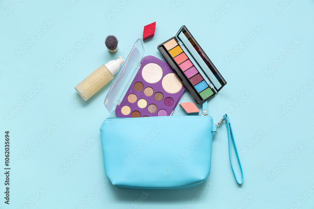 Cosmetic bag and makeup products on blue background