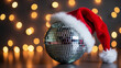 © Танюша Коновал - A disco mirror ball wearing a red festive santa hat. Christmas party concept