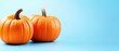 © Janis - Two orange pumpkins situated beside each other against a blue backdrop; include a space in the text