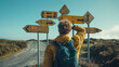 © Adamandgirls - A traveler contemplates multiple road signs, indicating various directions amidst a scenic landscape, highlighting the theme of exploration and decision-making.