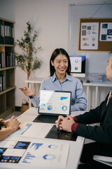 Fototapete - Young businesswoman presenting marketing data on a tablet to her colleagues during a business meeting in a modern office