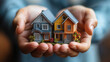 © Wararat - close-up of hands holding a small model house, symbolizing real estate investment and home ownership dreams