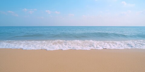 Wall Mural - serene beach scene with gentle waves and clear blue sky.