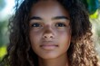 © Artsaba Family - Portrait of a young woman with natural beauty and curly hair, looking confidently into the camera