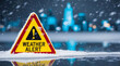 © CreativeMania - Bad weather alert in winter. Yellow warning sign pointing to heavy snow storm or blizzard. Bad weather conditions in the city with slippery icy road