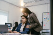 © PaeGAG - Asian businesswoman is consoling her upset colleague, placing a comforting hand on her shoulder as they navigate a challenging situation together in their modern office