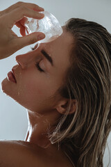 Wall Mural - Beautiful Young Woman Applying Ice Therapy to Her Face