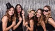 © hungry_cat - Group of Smiling Women Posing with Fun Props at Party, Silver Tinsel Backdrop