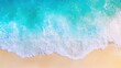 © soysuwan123 - Aerial view of turquoise ocean waves gently lapping at a sandy beach, showcasing the vibrant colors of water and shoreline.