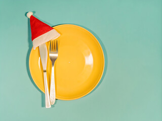 Silver knife fork and spoon with a Santa Claus red festive hat. Christmas meal background