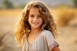 © Igor - Portrait of a beautiful little girl with curly hair in wheat field