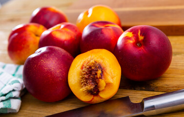 Ripe fresh juicy nectarines on wooden background on kitchen, harvest season