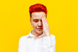 © Богдан Маліцький - young short-haired red-haired girl shows facepalm on a yellow isolated background, dissatisfied hipster woman with piercing shows mistake and fail
