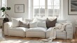 © Tina - A white sectional sofa with plush pillows and a throw blanket sits in a sunlit living room.