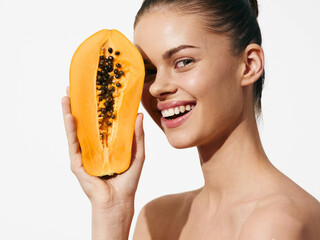 Woman enjoying the moment with eyes closed holding a fresh papaya fruit in front of her face