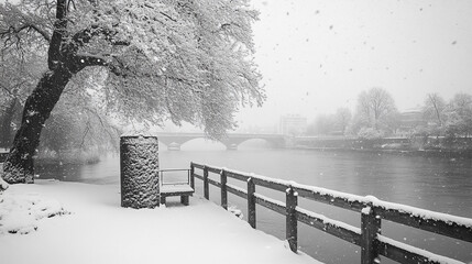 A snowy winter day at the riverside with falling snowflakes and a peaceful bench