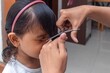 © fadfebrian - Mother cuts her daughter's hair with scissors at home. Haircut at home.