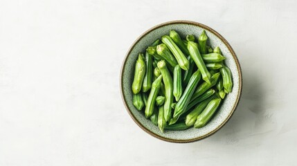 Top view of green okra in bowl, isolated on white, fresh and crisp