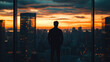 © Tahsin - Silhouette of a man overlooking a city at sunset from a high-rise building
