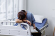 © David - Medical nurse is on bed in hospital sitting down a the hospital corridor in frustration and grief after failure and patient body condition