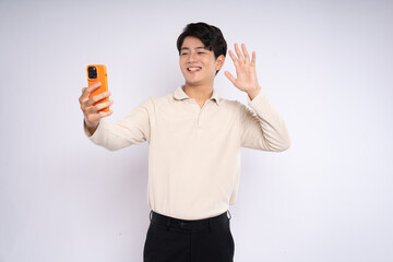 Portrait of young asian businessman wearing sweater and using phone on white background