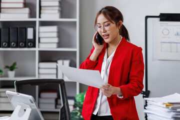 Asian busty employee, Young asian business woman holding paper while working and talking phone at office table, Happy office girl working, business people casual lifestyle