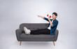 © STOCK88PHOTOGRAPHER - Full body image of young Asian man using hand speaker sitting on sofa on white background