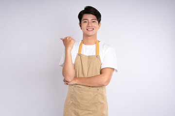 Portrait of young asian man wearing apron and posing on white background