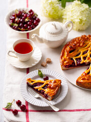 Wall Mural - Cherry, red berry sweet pie, cake with cup of tea. White background. Close up.